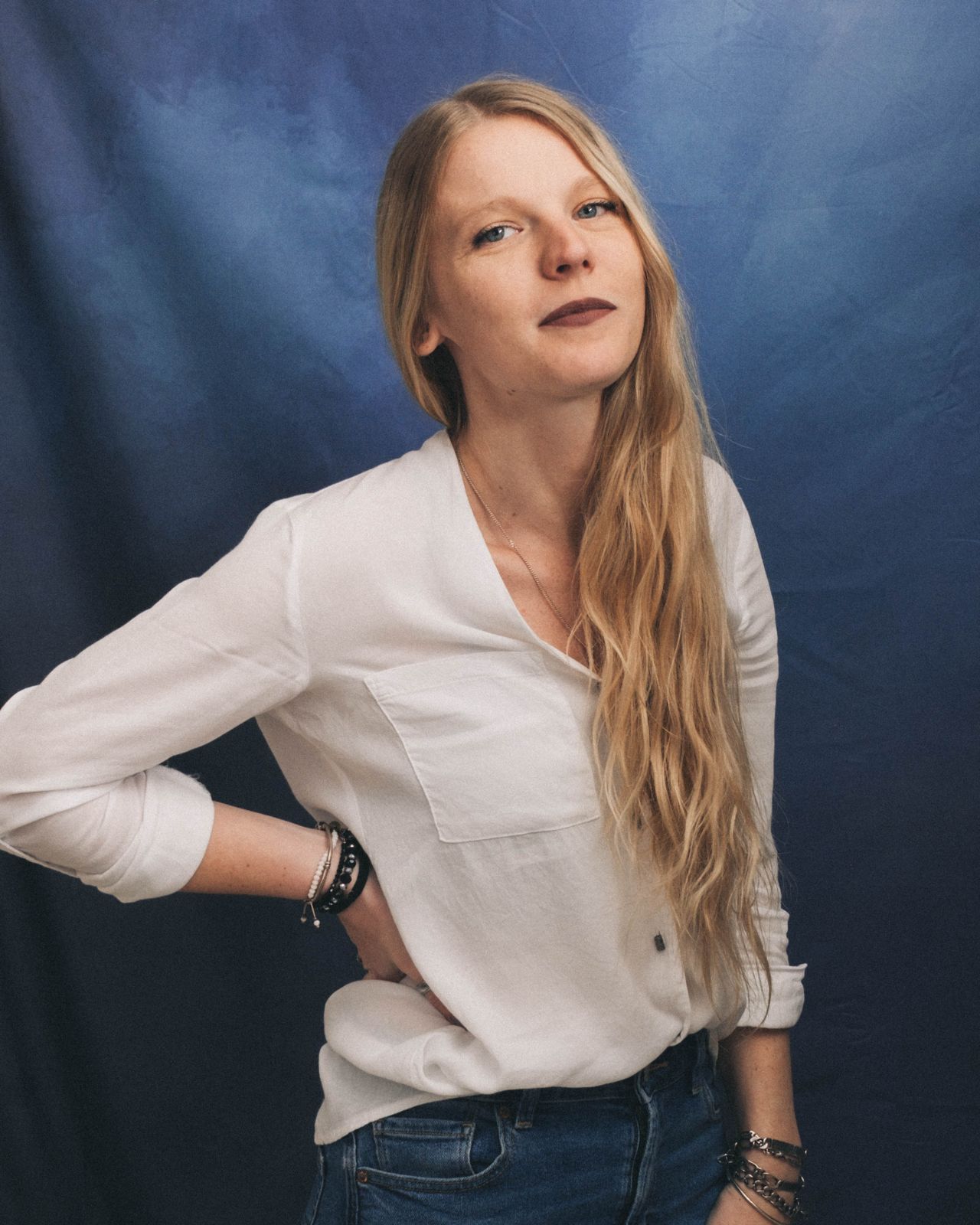 Kassandra in a white blouse against a blue backdrop