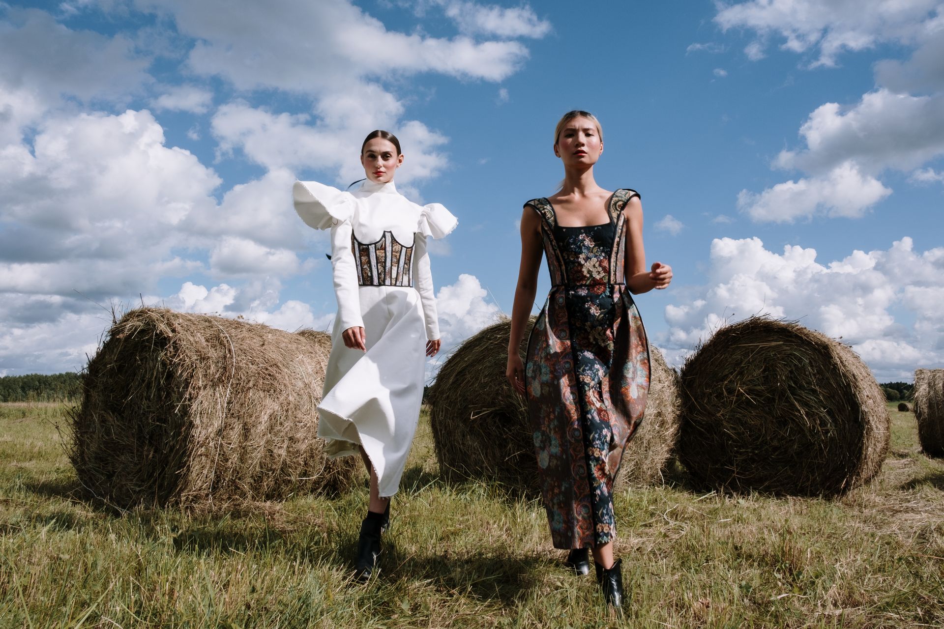 Two models in couture gowns in an open field