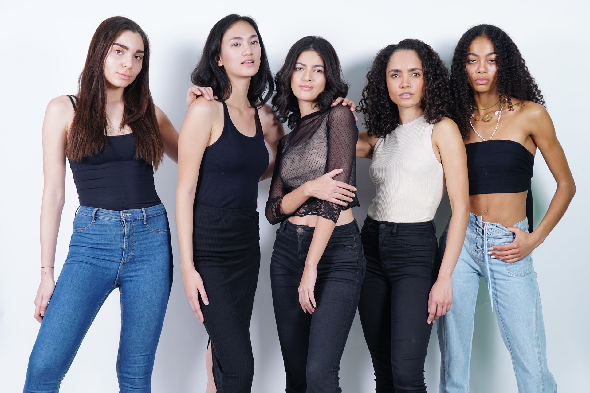 A group of five models standing together in the studio